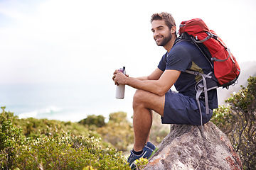 Image showing Hiking, mountain and man rest on a rock thinking after exercise, workout and fitness in nature for wellness. Travel, vacation and male person or athlete smile at a view after training and trekking