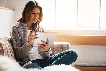 Image showing Bank, tablet and credit card with a woman online shopping on a sofa in the living room of her home. Ecommerce, finance payment and fintech banking with a young female online customer in her house