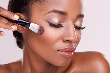 Image showing Beauty, makeup and black woman with brush on face in studio with cosmetic application tool. Skincare, blush and cosmetics, facial skin care model with luxury contour powder product on pink background