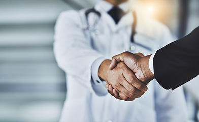 Image showing Closeup, doctor and man with handshake, consultation and partnership for healthcare development, growth and agreement. Zoom, medical professional and patient with greeting, shaking hands and wellness