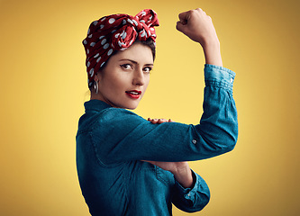 Image showing Woman, strong and flexing muscle portrait of a pinup girl in studio for beauty, power and fashion. Female person show bicep on a yellow background for motivation, freedom and retro or vintage style