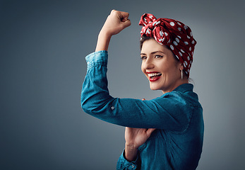 Image showing Strong, flexing muscle and happy girl in studio for support, women power and pinup fashion. Female person thinking and laughing for bicep on grey background for motivation, freedom and vintage mockup