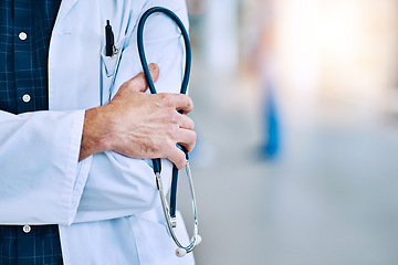 Image showing Healthcare, crossed arms and closeup of a doctor with a stethoscope in a hospital with mockup space. Career, professional and zoom of a male medical worker hand with equipment in a medicare clinic.