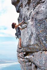 Image showing Rock climbing, blue sky and challenge with woman on mountain for adventure, travel and explore. Strong, freedom and cliff with female climber training in nature for courage, safety and workout