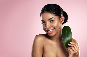 Image showing Portrait, happy woman and leaf of skincare in studio, pink background and mockup of eco friendly cosmetics. Face, smile and african model for natural beauty, green plants and aesthetic sustainability