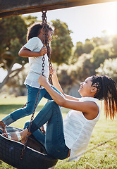 Image showing Mother, daughter and happy on swing at park, fun and playing together with smile outdoor. Love, care and bonding with family happiness, woman and girl enjoy time at playground with freedom in nature