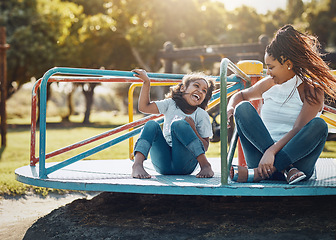 Image showing Mother with daughter on roundabout at park, playing together with laughter and fun outdoor. Love, care and bonding with family happiness, woman and girl enjoying time at playground with freedom