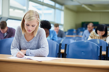 Image showing Lecture, woman and student writing, focus and education for development, knowledge and learning. Female person, young people or group in a room, notes and ambition at university, scholarship and test