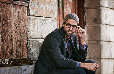 Image showing Thinking, fashion and man outdoor, winter and relax with trendy clothes, eyewear and thoughtful. Male person, model or guy with glasses, wonder or ideas with stylish outfit, relax or ponder in a city