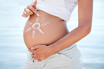 Image showing Pregnant, sunscreen and a woman on the beach during summer for sun protection or care on holiday or vacation. Mother, skincare and pregnancy with female tourist outdoor to apply sunblock to her belly