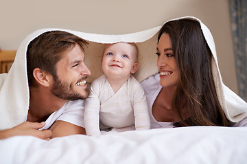 Image showing Happy family, parents and baby with blanket on bed for love, care and quality time together. Mother, father and playful newborn child relaxing in bedroom with bedding fort, smile and bonding at home