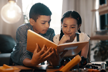 Image showing Education, children reading a book and in a living room at their home. Research information, knowledge or study and young siblings with textbook learning together as a team with robotics on table