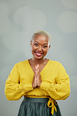 Image showing Praying hands, thank you and portrait of happy woman in studio with gratitude sign on wall background. Face, together hand and smile by female person showing space, prayer and worship emoji icon