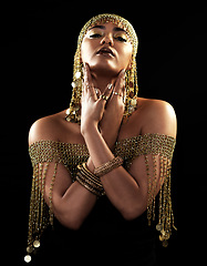 Image showing African woman, portrait and gold style with beauty and cosmetics in a studio. Isolated, black background and young female face with crown, Egypt fashion and queen empowerment with luxury and makeup