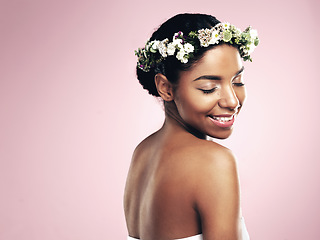 Image showing Woman, crown and flowers in hair, pink background and studio for natural beauty, plants and mockup. Happy african model, skincare and floral wreath for sustainability, eco friendly cosmetics and glow