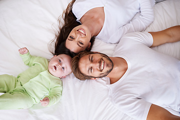 Image showing Top view of portrait, mother and father with baby on bed for love, care and quality time together. Happy parents, family and newborn child relaxing in bedroom for smile, happiness and bonding at home