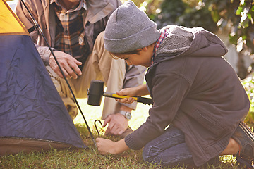 Image showing Dad, kid and hammer tent for camping outdoor in nature on vacation, bonding together and summer. Father, boy and preparing camp, learning and helping in forest for travel, education and adventure.