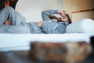 Image showing Tired, sleep and a man with a headache on a bed with burnout, looking sad and depressed. Fatigue, insomnia and a person with depression, anxiety or a migraine problem in the bedroom of a house