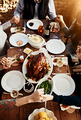 Image showing Food, table and people praying and holding hands while eating together for holiday celebration. Above group of family or friends pray for thanksgiving lunch, chicken or turkey and wine drinks