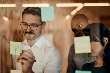 Image showing Businessman, writing and brainstorming in meeting for planning, schedule or team strategy at the office. Man employee in leadership or presentation for training staff on sticky note or project plan