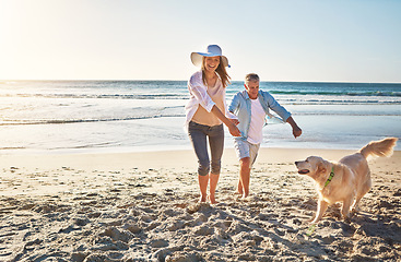 Image showing Happy couple, holding hands and at the beach with a dog for walking and retirement travel in Indonesia. Smile, playful and elderly man and woman on a walk at the sea with a pet for play and holiday