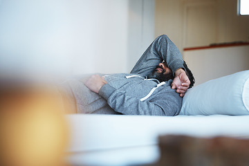 Image showing Tired, insomnia and a man with stress on a bed with burnout, sad and mental health problem. Fatigue, depression and a person sleeping in the bedroom of a house while depressed or sick with a hangover