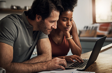 Image showing Couple, finance and laptop in a kitchen for planning, budget and savings or paying bills together in their home. Interracial marriage, online and people with tax, mortgage or home loan or insurance