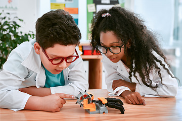 Image showing Engineering, learning and children building a robot hand together in a classroom at school and being curious. Clever, education and young engineer students working in a science class doing research