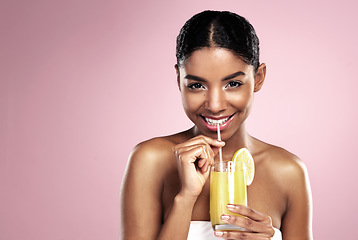 Image showing Portrait, happy woman and glass of orange juice in studio for healthy nutrition, vitamin c diet or mockup on pink background. African model, fruit cocktail and citrus drink for natural skincare detox