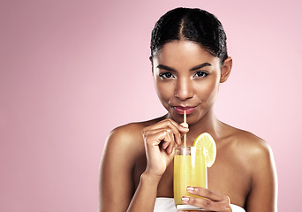 Image showing Portrait of woman, glass and orange juice in studio for healthy nutrition, vitamin c or mockup on pink background. African model drinking fruit cocktail, citrus smoothie and natural diet for skincare