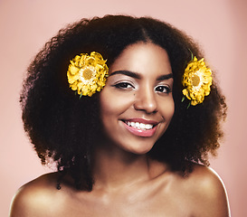 Image showing Portrait of happy woman, hair care and face with yellow flowers, natural beauty or pink background in studio. African model, skincare and daisy plants in afro for sustainable cosmetics, smile or glow