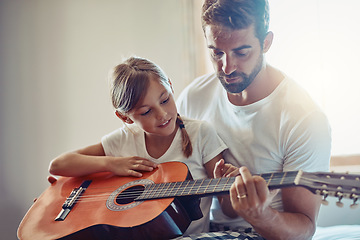 Image showing Father with daughter, guitar with teaching and learning at home, bonding with love and creativity. Family, man and girl learn to play musical instrument, lesson and music education with talent