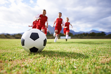 Image showing Running, teamwork and sports with children and soccer ball on field for training, competition and fitness. Game, summer and action with football player and kick on pitch for goals, energy and athlete