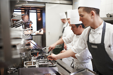 Image showing Catering, professional chefs cooking food and in kitchen of a restaurant. Service or fine dining, hospitality or accommodate and staff or group of people preparing meal for lunch or dinner together