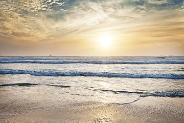 Image showing Beach, water and ocean with sunrise and mockup with blue sky and waves on horizon. Sea landscape, outdoor and nature with sunshine at the coast and seaside with sand and no people with clouds