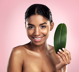 Image showing Portrait, happy woman and leaves for natural beauty in studio, pink background and eco friendly vegan cosmetics. Face, african model and healthy skincare of plants, green leaf and sustainable shine