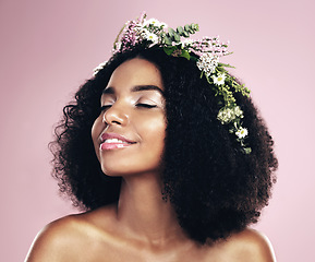 Image showing Woman, face and flower crown for beauty in studio, pink background and natural glowing skincare. African, female model and floral wreath of plants, sustainable cosmetics and eco friendly dermatology