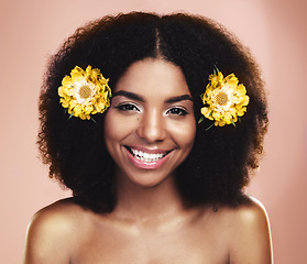 Image showing Portrait of happy woman, afro and yellow flowers in studio background for beauty, floral aesthetic and shine. Face of african model, skincare and daisy plants in hair for happiness, perfume or makeup