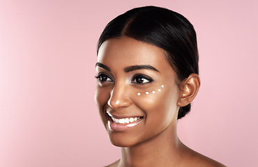 Image showing Thinking, skincare and face of woman with eye cream in studio isolated on pink background mockup. Dermatology, creme cosmetics and happy Indian female model with moisturizer lotion for healthy skin.