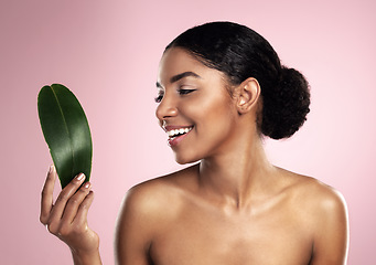 Image showing Woman, smile and leaf of skincare in studio, pink background and eco friendly facial cosmetics. Face, happy and african model with natural beauty, green plants and sustainability of vegan dermatology