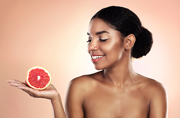 Image showing Grapefruit, natural beauty and happy woman in studio, background and sustainable mockup. African model, healthy skincare and citrus fruits for cosmetics, organic dermatology and vitamin c benefits