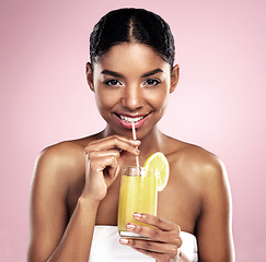 Image showing Portrait, woman and orange juice in studio for beauty, healthy nutrition or vitamin c benefits on pink background. Happy african model, glass and fruit cocktail drink, citrus smoothie or natural diet