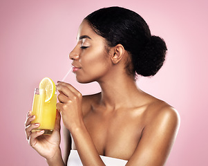 Image showing Face of woman, orange juice and drink in studio, pink background and detox for healthy skincare. African model, citrus smoothie and vitamin c fruits for nutrition benefits, natural beauty or wellness