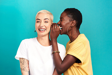 Image showing Whisper, secret and girl friends portrait with privacy, laugh and gossip in a studio. Blue background, women and smile of a female person with diversity and funny news telling a story and listening