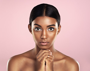 Image showing Face portrait, skincare and serious woman in studio isolated on a pink background. Natural beauty, aesthetic and Indian female model with makeup, cosmetics and spa facial treatment for healthy skin.