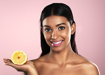 Image showing Face, skincare and smile of woman with an orange in studio isolated on pink background. Fruit, natural cosmetics and portrait of Indian female model with food for healthy diet, vitamin c or nutrition