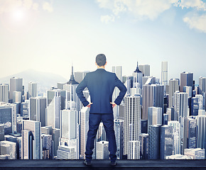 Image showing Back, view of the city and a business man standing hands on hips outdoor with a vision or mindset of success. Proud sky and buildings with a male corporate employee looking out over an urban town