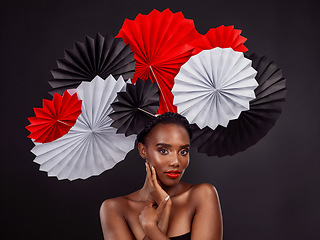 Image showing Beauty, portrait and black woman with origami fans in studio isolated on a dark background. Serious face, makeup cosmetics and skincare of female model with traditional Japanese paper art for culture