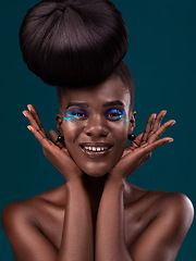 Image showing Portrait, hands and makeup with an african woman in studio on a blue background for beauty or cosmetics. Face, hair or fashion with a happy and attractive young female model at the salon for style