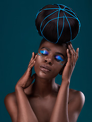 Image showing Face, hair and makeup with a model black woman in studio on a blue background for beauty. Hands, haircare and cosmetics with an attractive young female person at the salon for fashion or styling